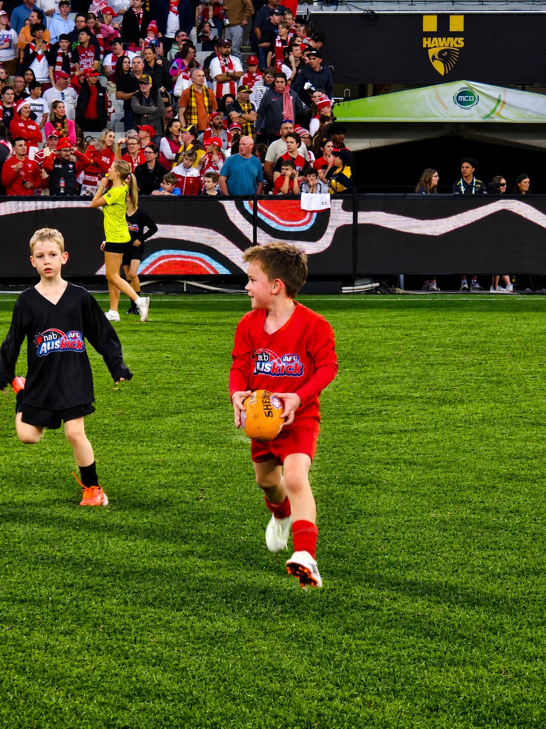 A young football player carrying the ball on the field